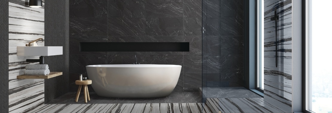 Stunning wet room with free-standing bathtub, shower wall, floor, and niche of black marble look tile with white & black tile accents, black matte shower fixtures, floating vanity countertop & shelf.