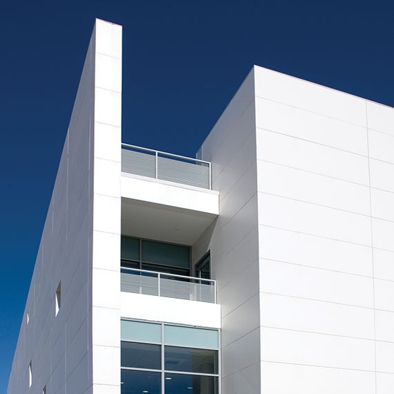 Exterior view of a commercial building covered with large format white porcelain cladding.