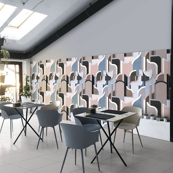 Restaurant with gray stone look floor tile, large-format ceramic wall tile with blue, pink, beige, black and white designs, dining tables with chairs.