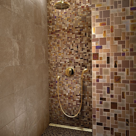 Large walk-in shower with brown and beige mosaic on the wall with various sizes of square and rectangular tile.