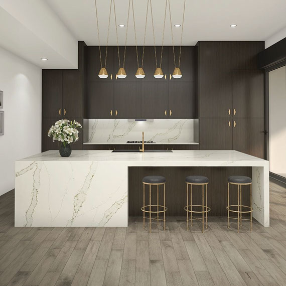 Kitchen with dark wood cabinets, marble look off-white & beige quartz countertop, backsplash, and waterfall island, and brass pendants.